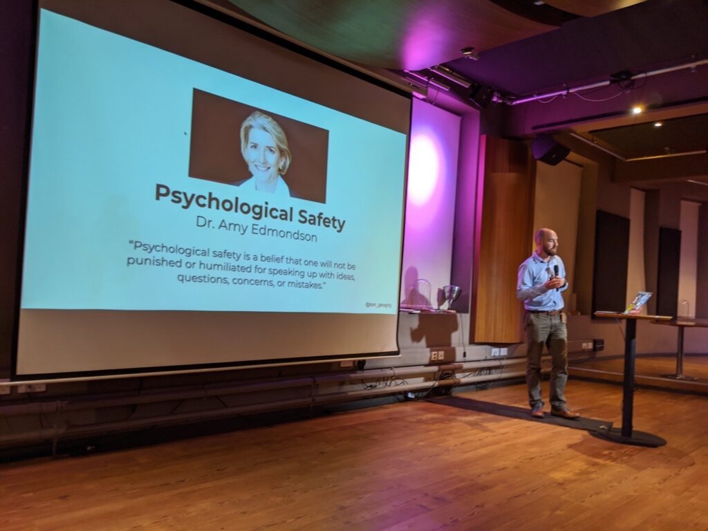 Tom Geraghty talking about psychological safety with a slide showing amy edmondson